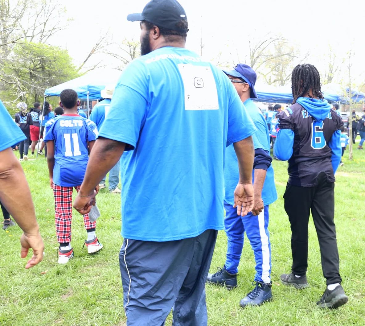 Bobby Christian walking with young Eastside Colts players in their jerseys